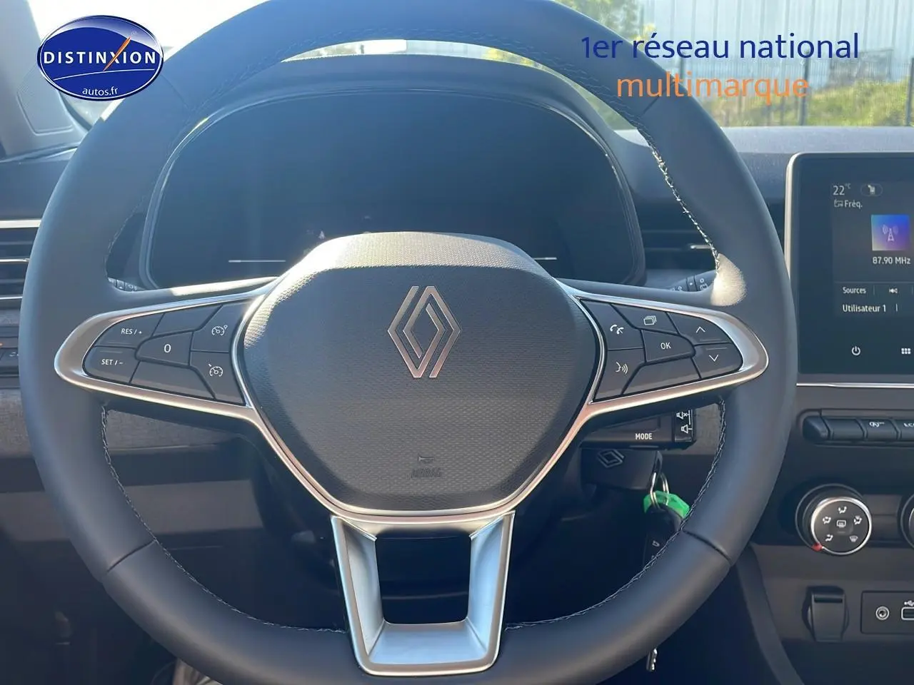 Volant multifonction Renault Clio V en gros plan avec tableau de bord et écran tactile visible en arrière-plan.