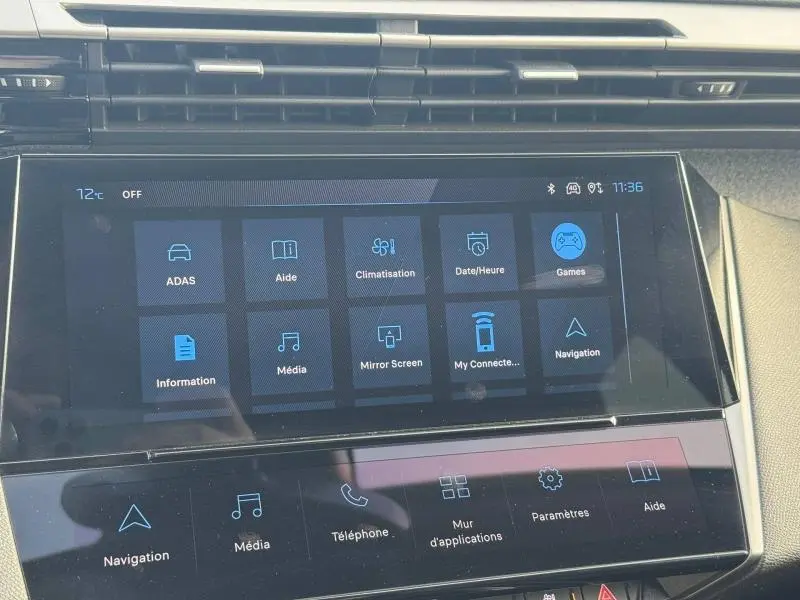 Écran tactile central du tableau de bord du Peugeot 308 2024 en Gris Artense, affichant les menus de navigation et médias.