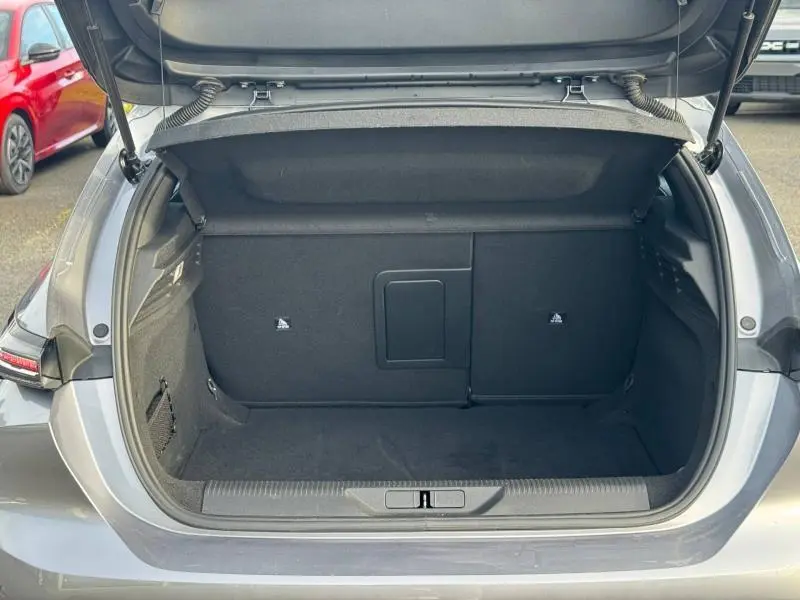 Coffre ouvert vu de l'arrière d'une Peugeot 308 2024 gris Artense, montrant un espace de chargement propre et spacieux.