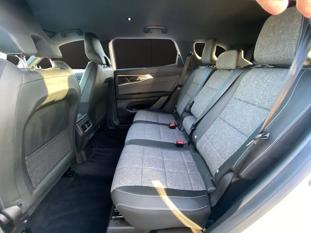Vue intérieure côté droit sur la banquette arrière 3 places en tissu gris et cuir noir du Renault Espace 2025 blanc nacré.