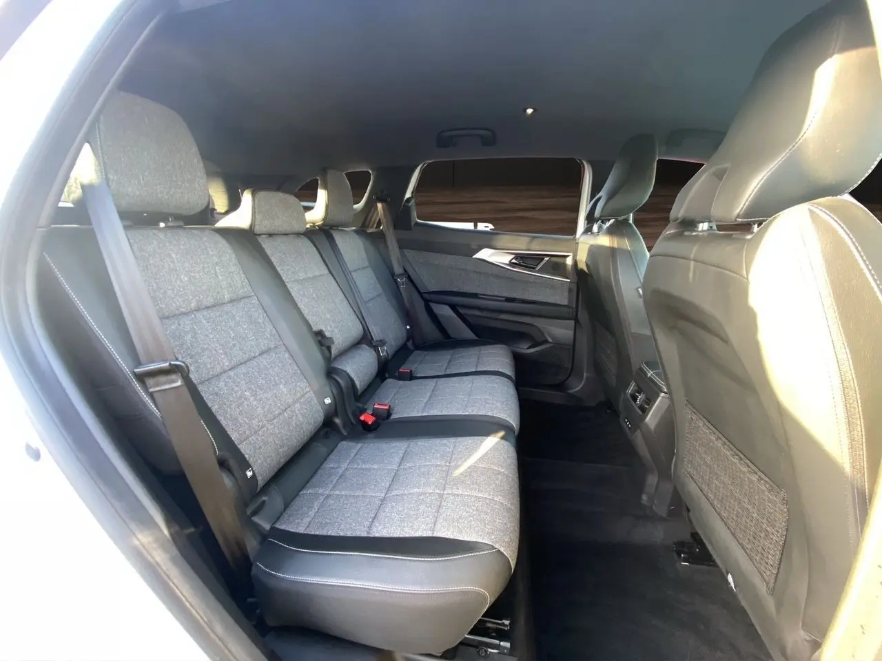 Vue intérieure côté gauche sur la banquette arrière 3 places en tissu gris et cuir noir du Renault Espace blanc nacré 2025.
