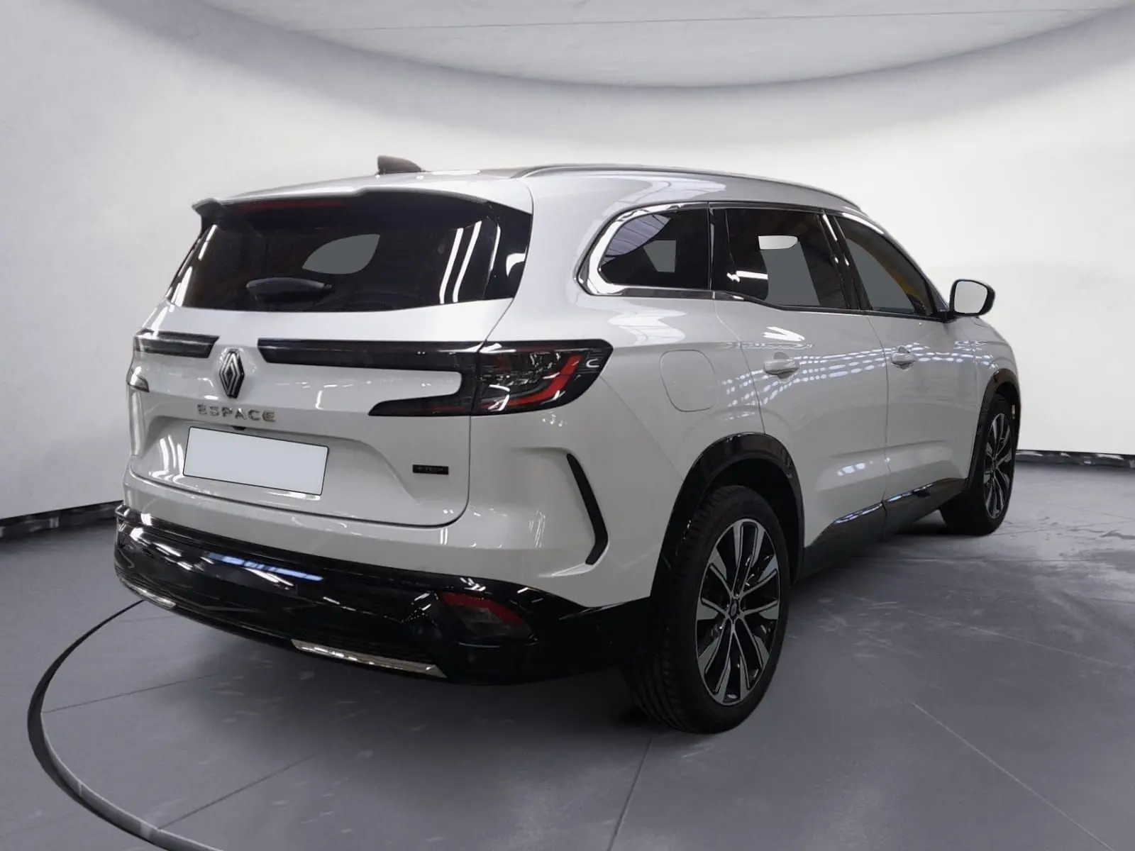 Vue 3/4 arrière droite du Renault Espace blanc nacré 2025 avec jantes alliage noires et toit noir brillant.