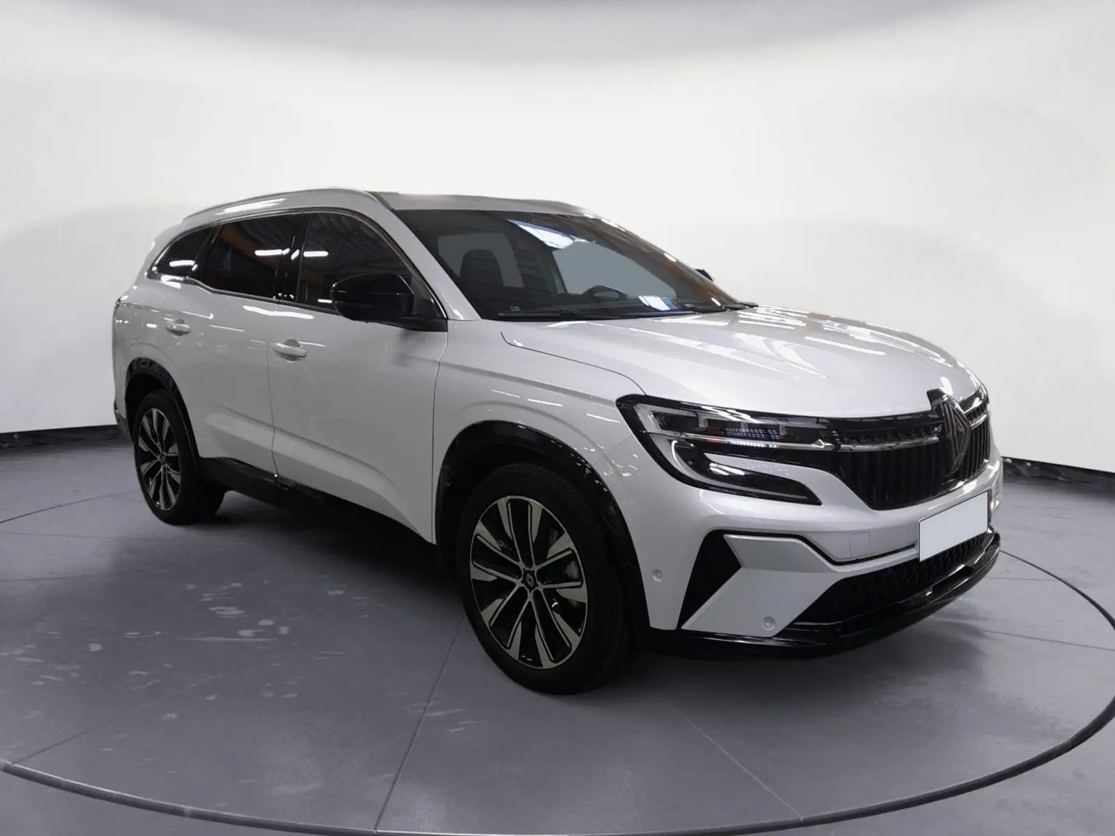 Renault Espace blanc nacré en 3/4 avant droit, avec jantes alliage noires et toit noir contrasté.