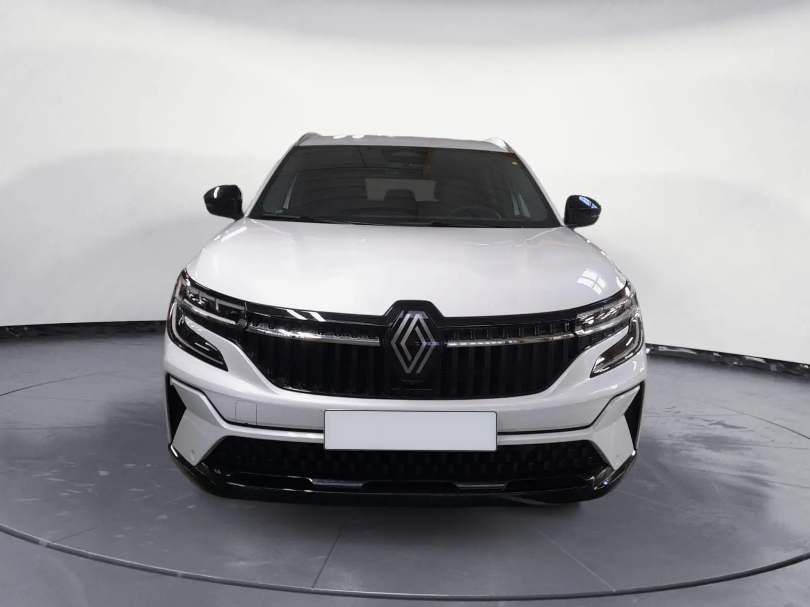 Vue frontale du Renault Espace blanc nacré 2025 avec calandre noire et feux LED adaptatifs.