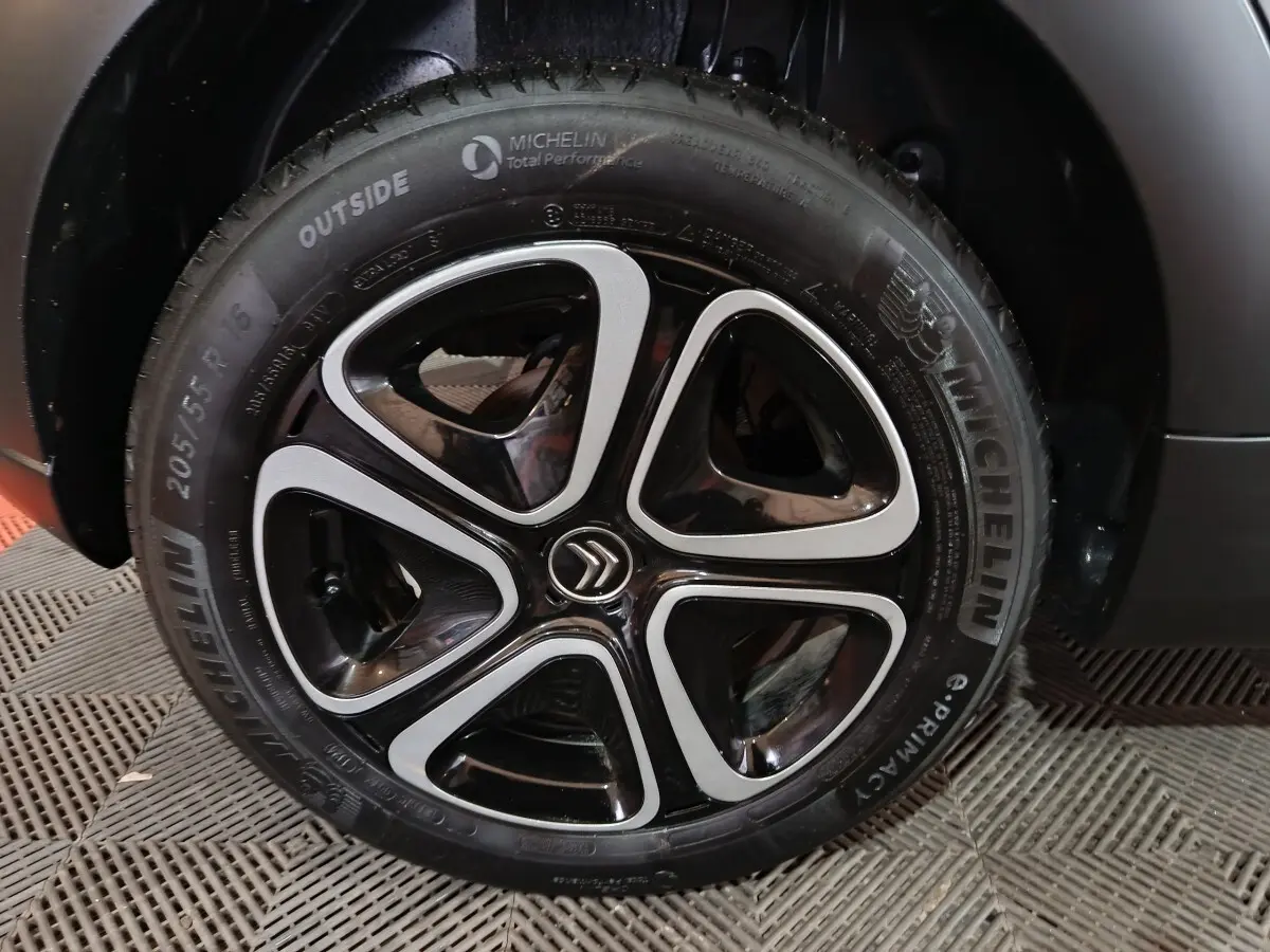 Gros plan sur la roue avant droite gris clair de la Citroën C3 BlueHDi 100 BVM PLUS avec jante noire et argentée.