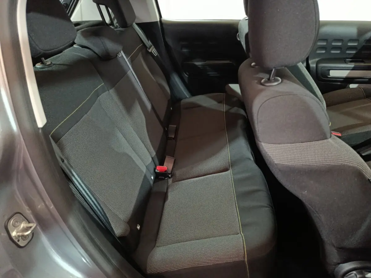 Vue intérieure côté gauche montrant la banquette arrière noire de la Citroën C3 gris clair 2024.