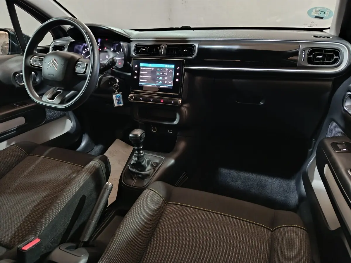 Intérieur du Citroën C3 2024 Diesel, vue de l'habitacle côté conducteur avec tableau de bord noir et écran tactile central.