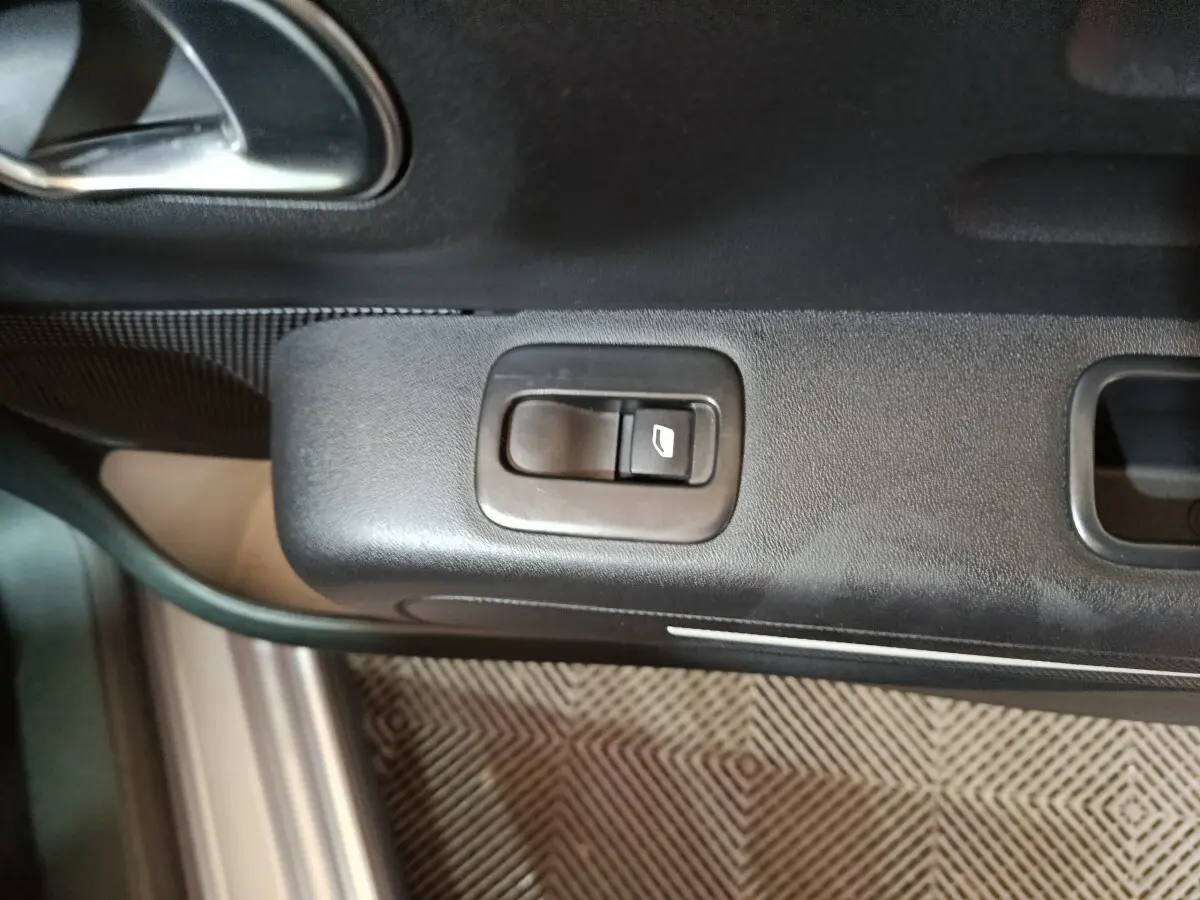 Bouton de commande de la vitre électrique sur la porte côté conducteur du Citroën C3 gris clair 2024.