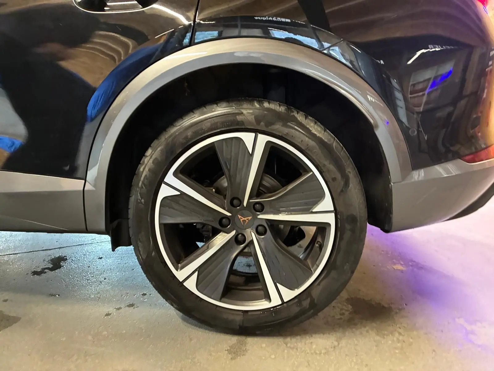 Gros plan sur la roue arrière droite d’un CUPRA Formentor noir avec jante alu bicolore et logo CUPRA central.