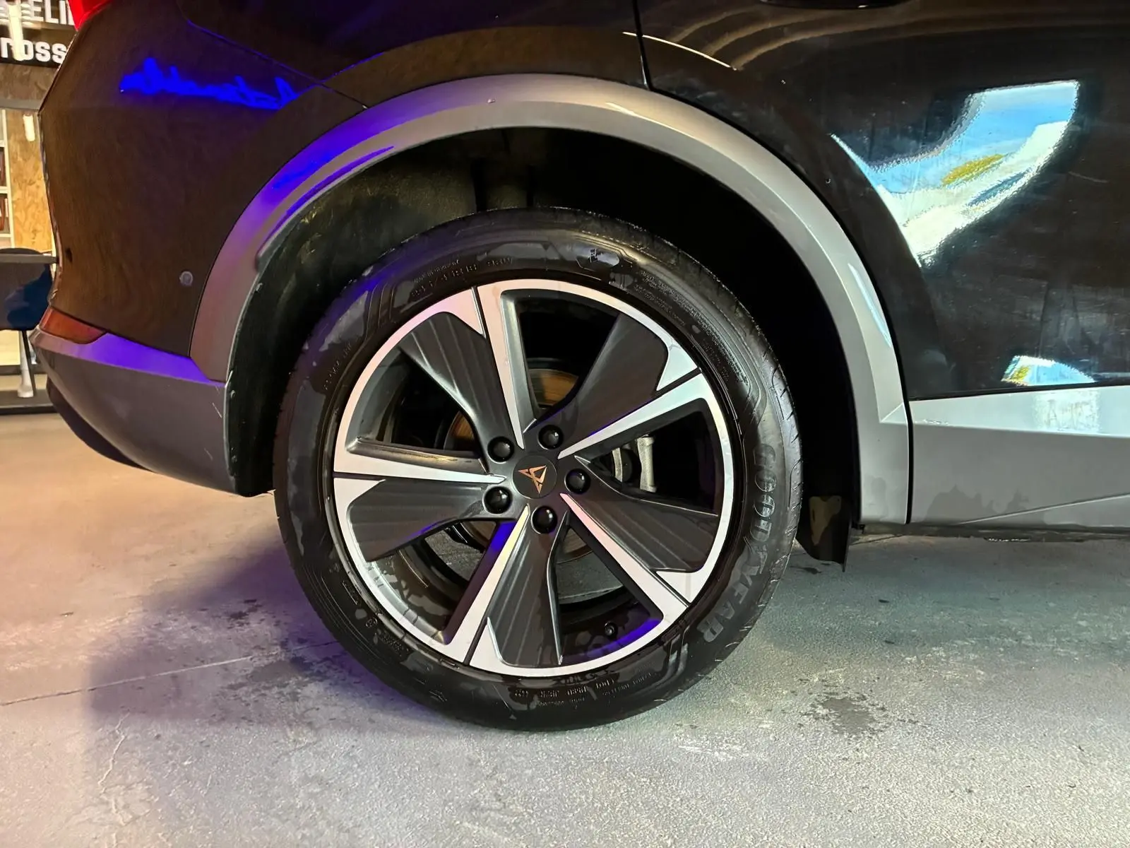 Gros plan sur la roue arrière droite d'une CUPRA Formentor noire avec jante alu bicolore et logo CUPRA central.