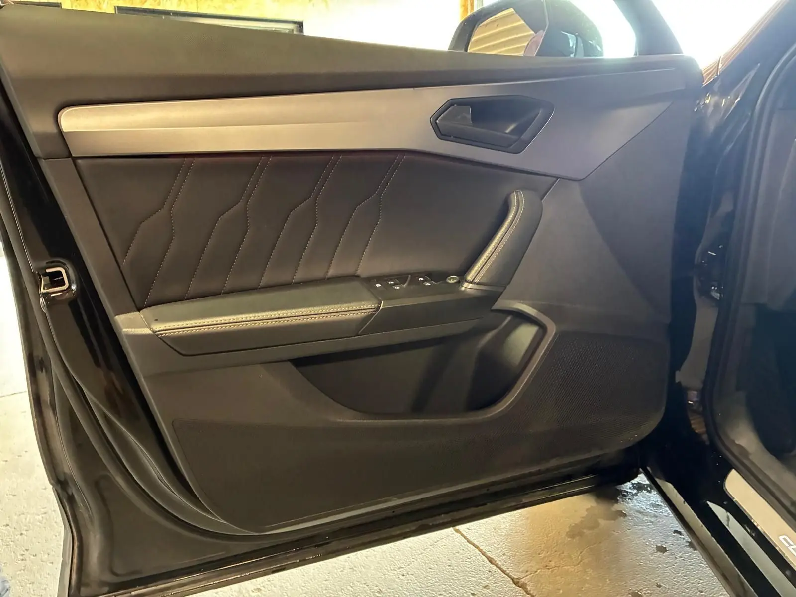 Vue intérieure de la porte avant gauche noire du CUPRA Formentor 2022 avec surpiqûres et commandes de vitres.