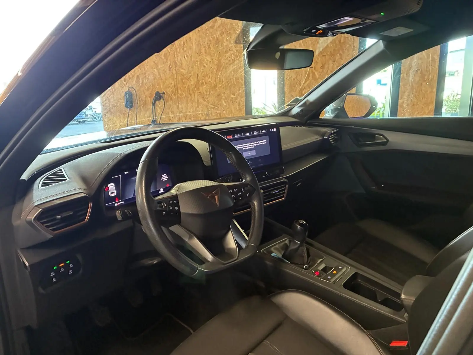 Vue intérieure côté conducteur de la CUPRA Formentor noire, avec volant multifonction, écran tactile et boîte manuelle.