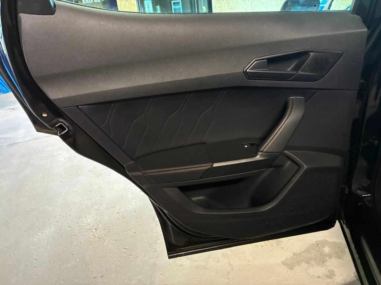 Vue rapprochée de la porte arrière gauche noire du CUPRA Formentor 2.0 TDI avec surpiqûres cuivrées et poignée intégrée.
