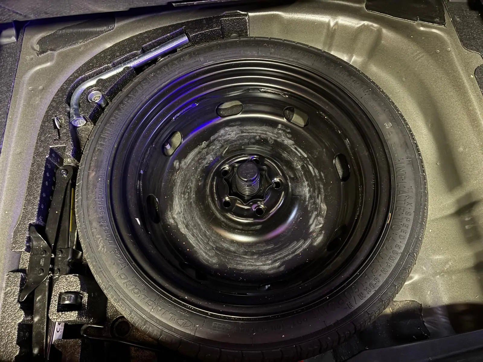 Vue plongeante sur la roue de secours noire et les outils de bord dans le coffre d'une CUPRA Formentor 2.0 TDI 150 V.