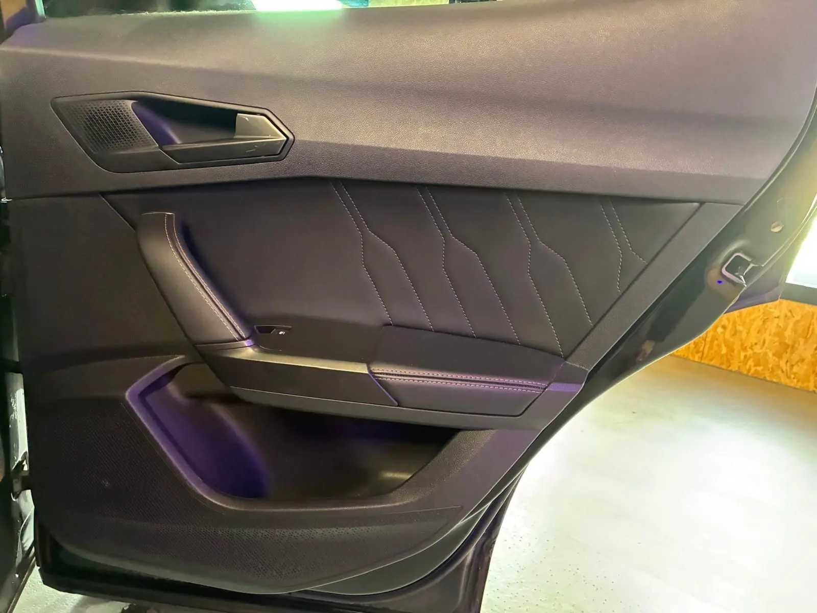 Vue rapprochée de la porte intérieure côté gauche du CUPRA Formentor noir, avec surpiqûres et poignée intégrée.