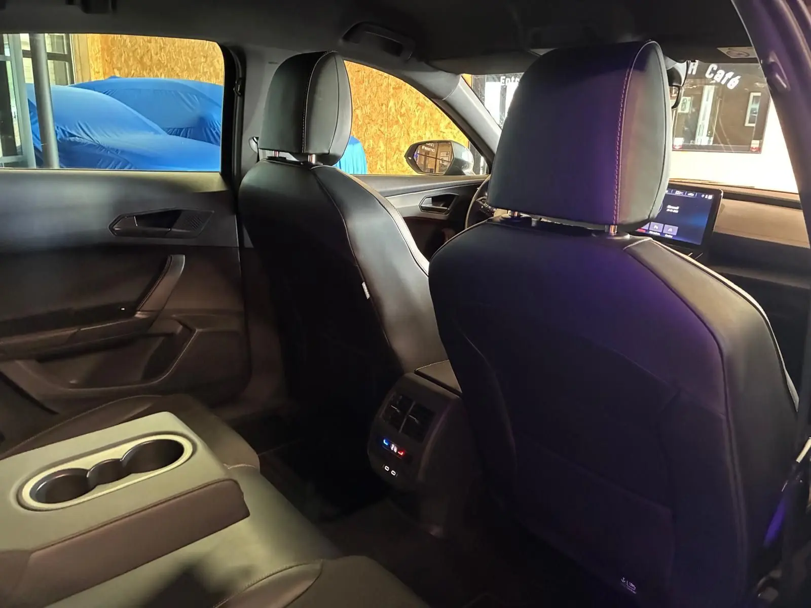 Vue intérieure arrière du CUPRA Formentor noir, montrant les sièges avant et la console centrale avec commandes climatisation.