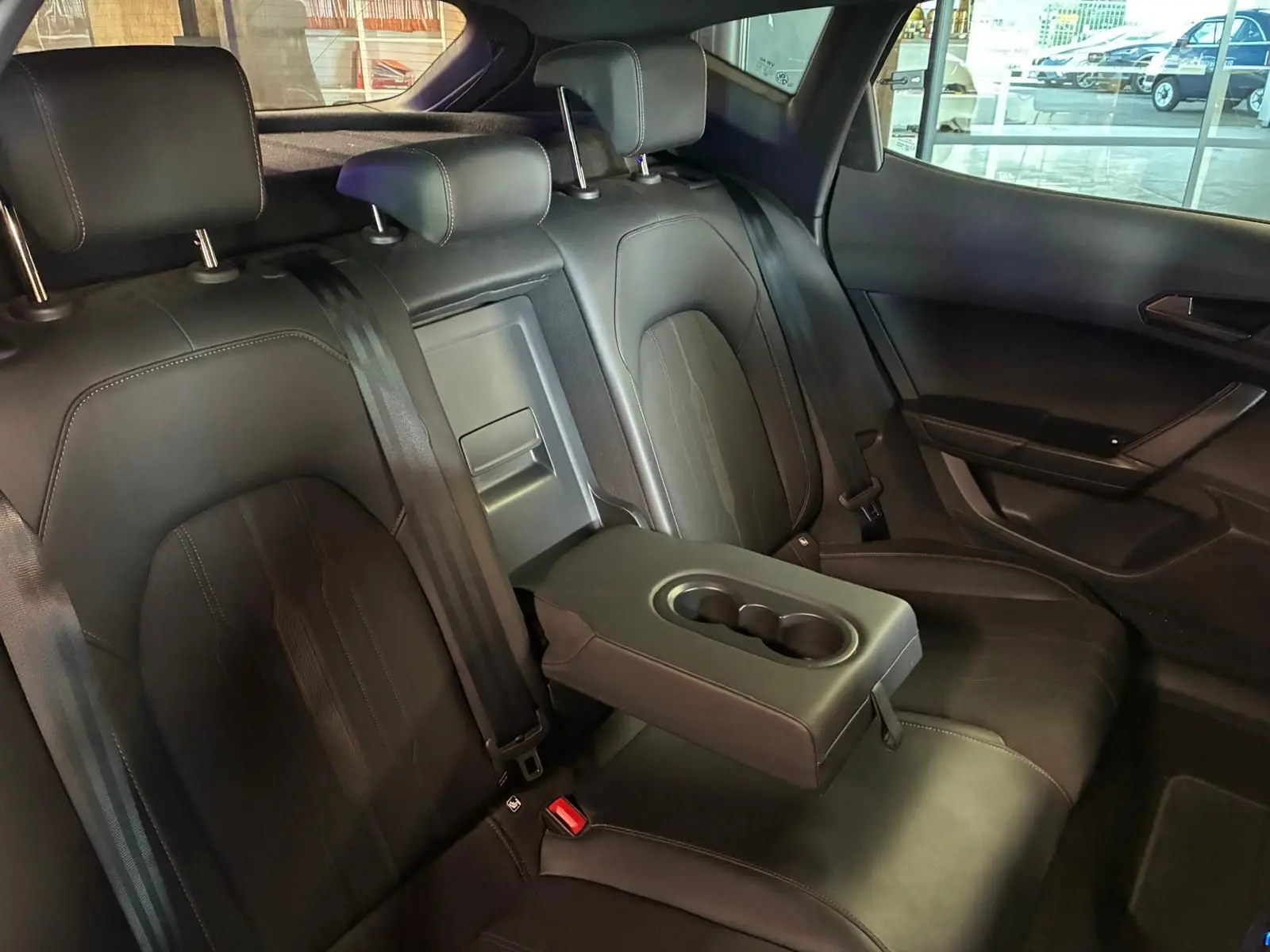 Vue intérieure des sièges arrière noirs du CUPRA Formentor 2.0 TDI 150 V avec accoudoir central et porte-gobelets déployé.