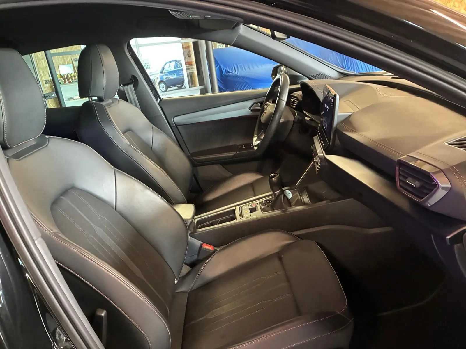 Vue intérieure côté conducteur du CUPRA Formentor noir, montrant sièges en cuir, tableau de bord et volant multifonction.