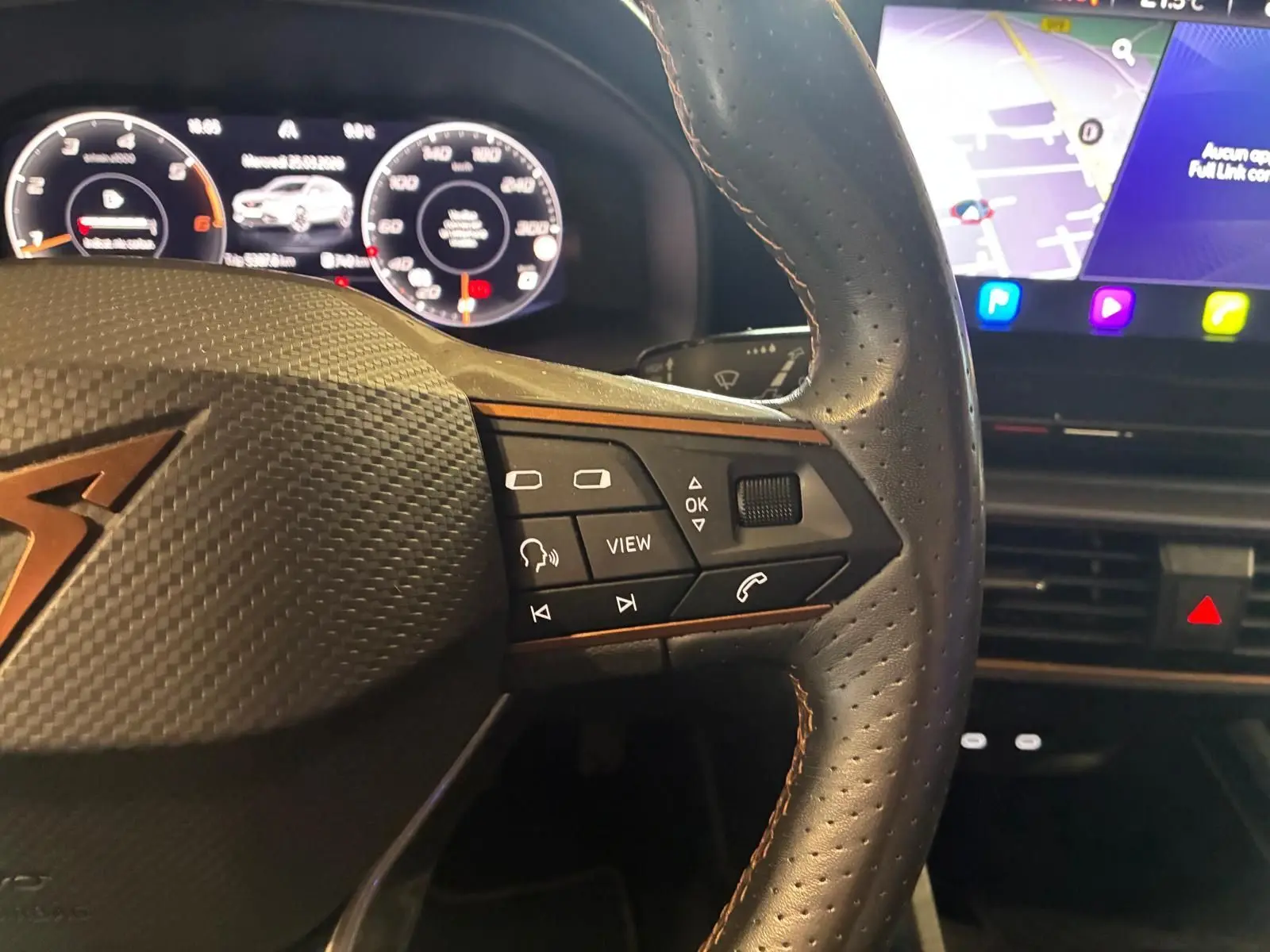 Gros plan sur le volant noir perforé de la CUPRA Formentor 2.0 TDI 150 V avec commandes multifonctions et tableau de bord numérique.