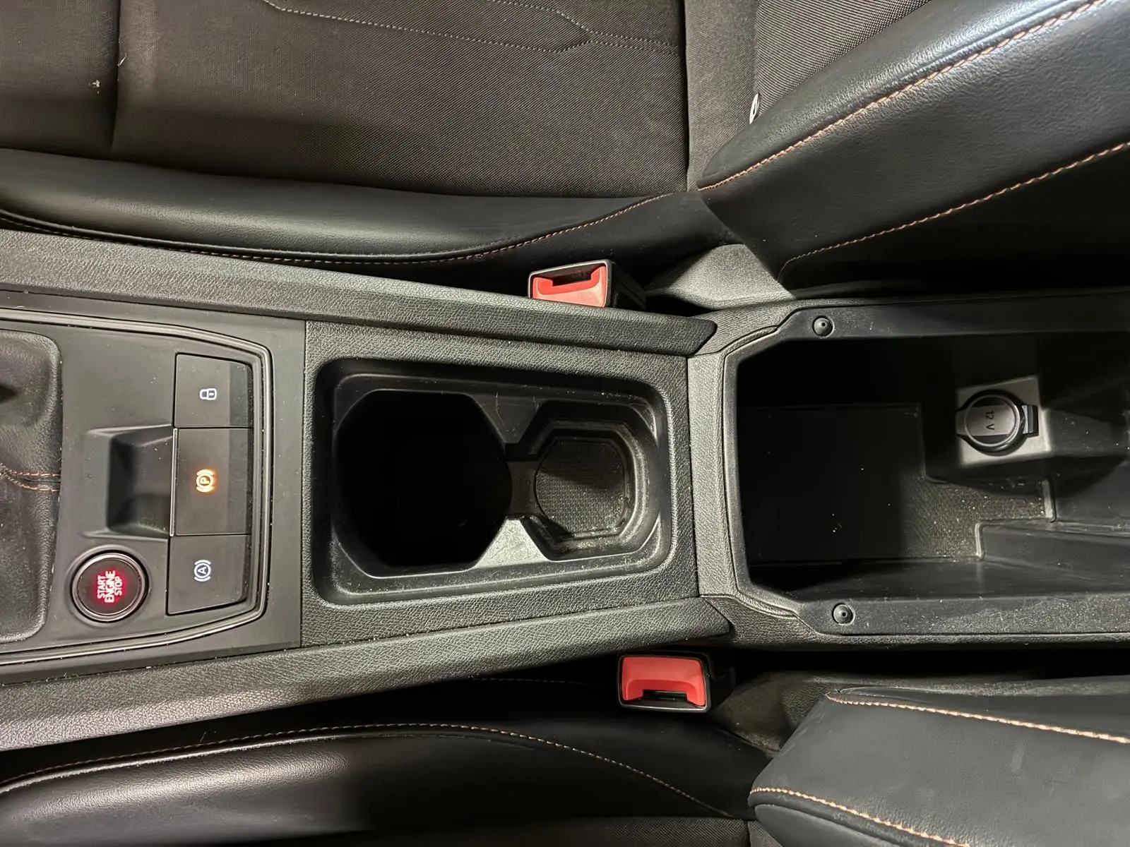 Vue rapprochée de la console centrale noire du CUPRA Formentor 2.0 TDI avec bouton start et porte-gobelets.