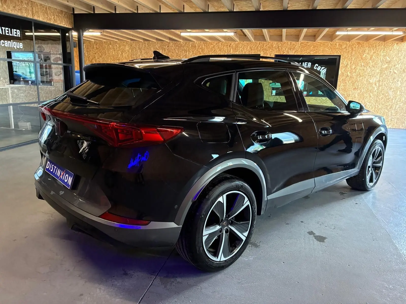 Vue 3/4 arrière droite du CUPRA Formentor noir 2022 avec jantes alu et double sortie d'échappement stylisée noire.