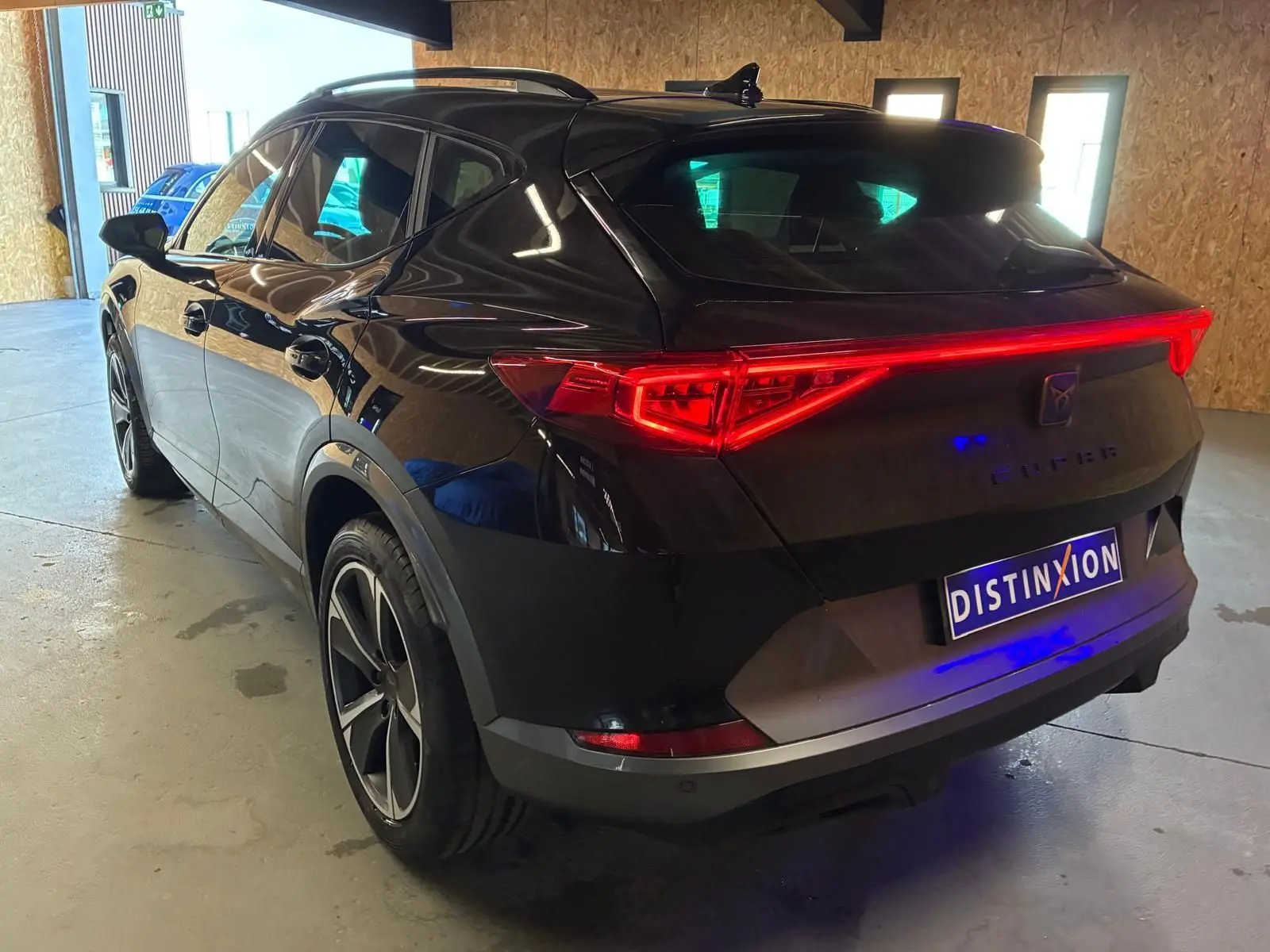 Vue 3/4 arrière droite du CUPRA Formentor noir avec feux arrière Tri-LED et double sortie d'échappement noire stylisée.