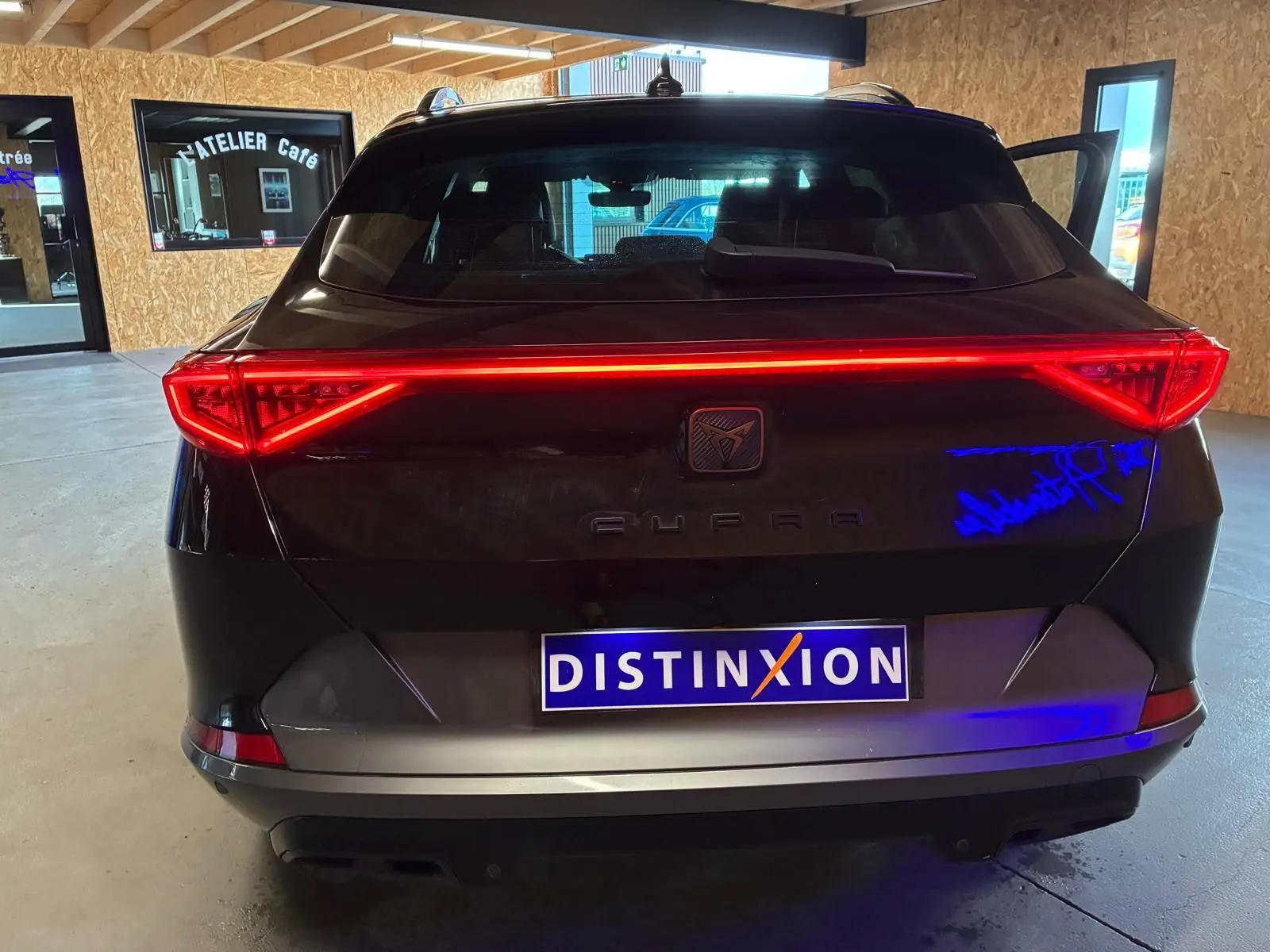 Vue arrière d'une CUPRA Formentor noire 2022 avec feux LED allumés et double sortie d'échappement noire stylisée.