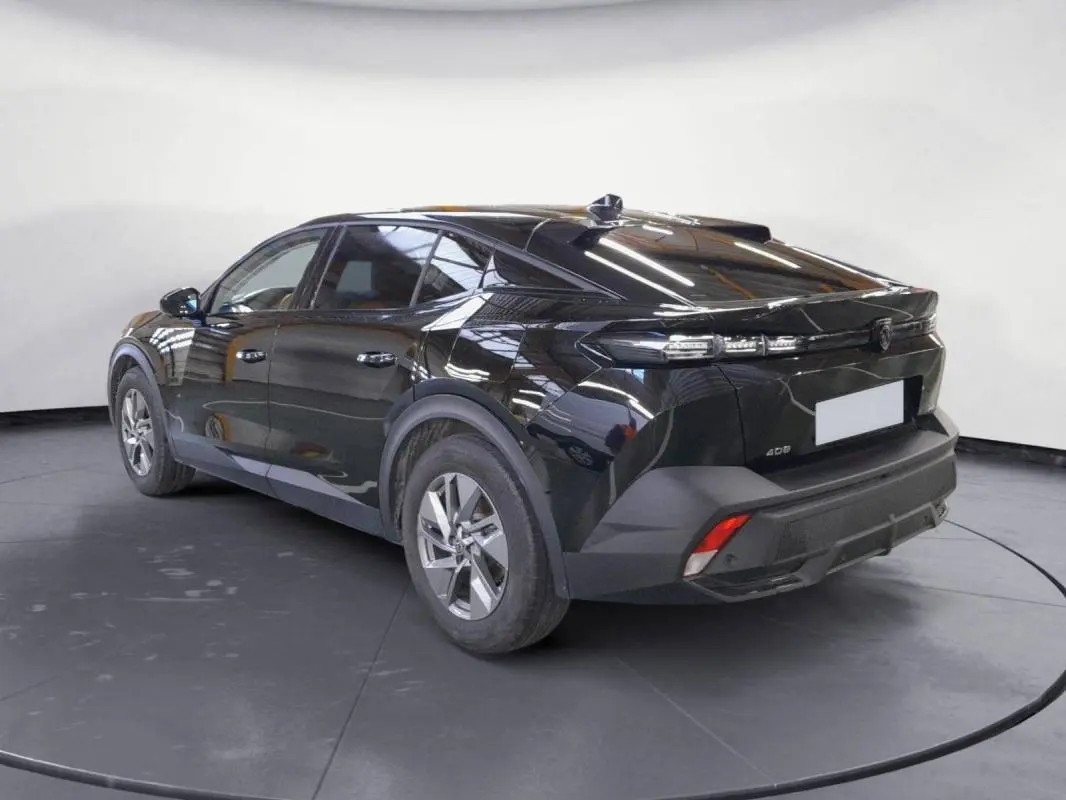 Peugeot 408 PHEV noir vue 3/4 arrière droit, jantes alliage 17 pouces et feux arrière LED distinctifs.