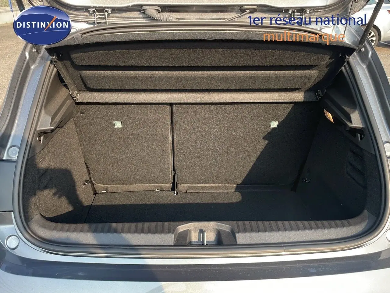 Coffre ouvert d'une Renault Clio 1.5 DCI 100ch Evolution gris schiste métal, vue arrière montrant l'espace de chargement.