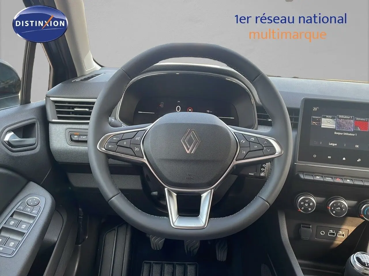 Vue centrée sur le volant de la Renault Clio gris schiste, avec tableau de bord numérique et écran tactile visible.