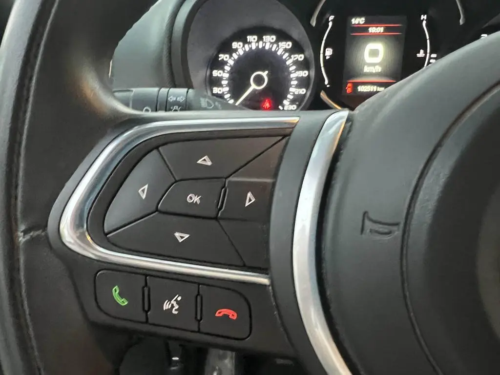 Gros plan sur les commandes au volant à gauche du tableau de bord du Fiat 500L 2017 avec affichage numérique du compteur.