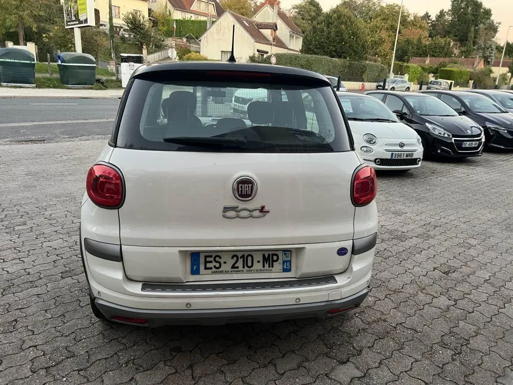Vue arrière d'une FIAT 500L blanche avec toit noir, feux arrière ronds et logo 500L bien visible.