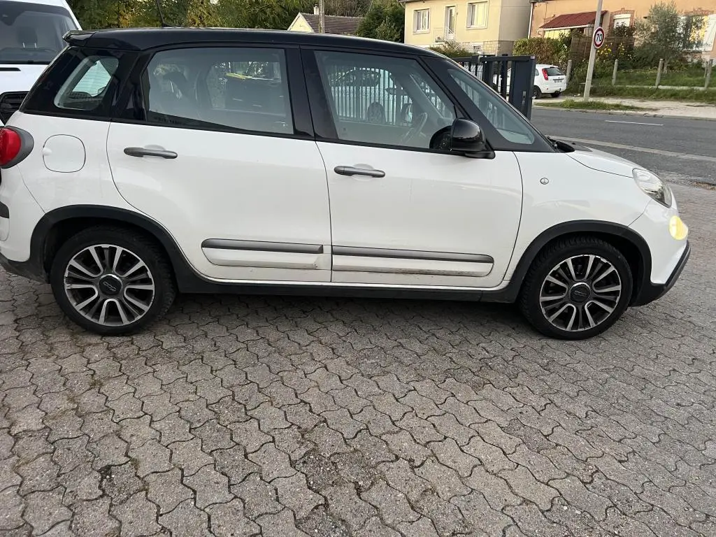Profil côté gauche d'une FIAT 500L 2017 bi-color avec toit noir, roues alliage et poignées de porte grises.