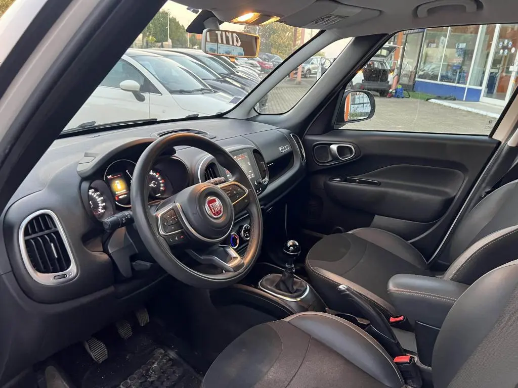 Intérieur avant droit d'une Fiat 500L 2017 avec tableau de bord noir, volant multifonction et levier de vitesse manuel.