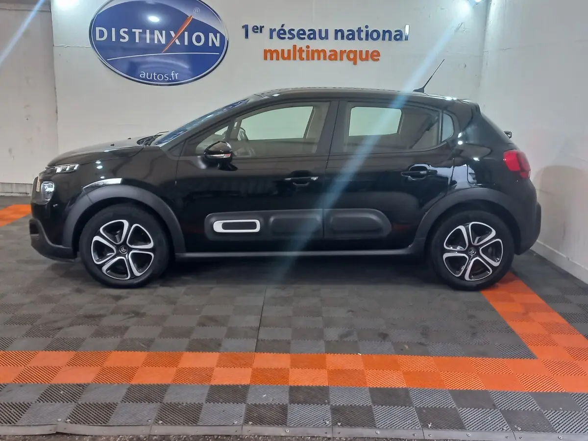 Vue de profil côté gauche d'une Citroën C3 noire 2024 avec protections latérales caractéristiques et jantes stylisées.
