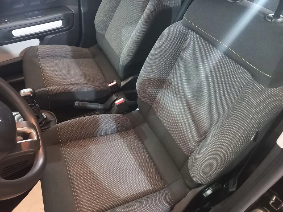 Vue intérieure rapprochée des sièges avant gris foncé et de la boîte manuelle d'une Citroën C3 noire 2024.