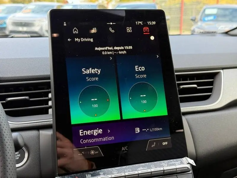 Écran tactile central du Renault Captur 2025 affichant scores Safety et Eco, intérieur moderne avec tableau de bord gris.