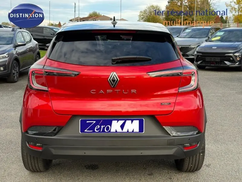 Vue arrière d'un Renault Captur 2025 rouge flamme, version hybride, avec logo et feux arrière distinctifs allongés.