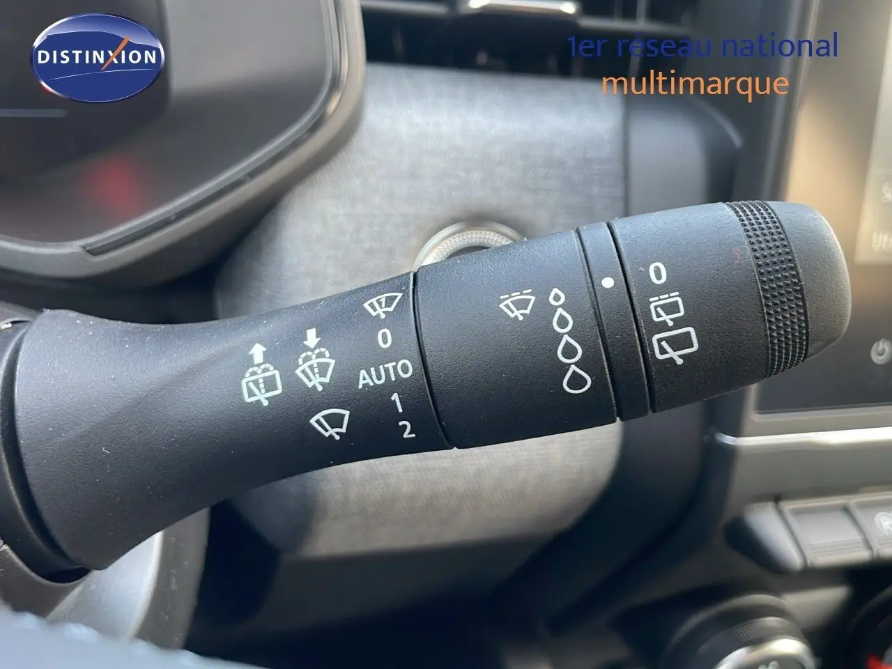 Gros plan sur la commande d'essuie-glace d'une Renault Clio noire étoile métal, version 1.5 DCI 100CH Evolution.