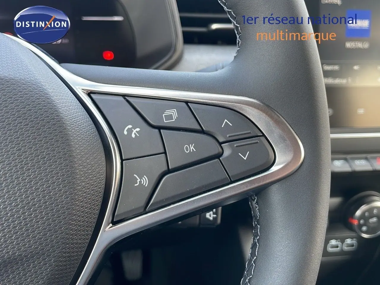 Gros plan sur les commandes multifonctions à droite du volant noir de la Renault Clio 1.5 DCI 100CH Evolution 2025.