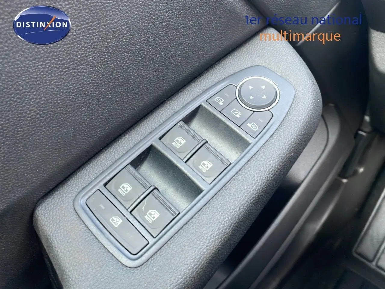 Gros plan sur les commandes des vitres électriques côté gauche d'une Renault Clio noire étoile métal, version 2025.