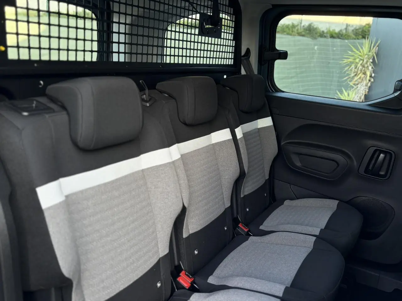 Vue intérieure côté droit des trois sièges arrière indépendants gris et noirs du Citroën Berlingo Multispace 2025.