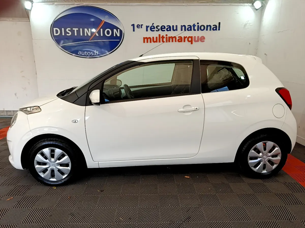 Vue de profil côté gauche d'une Citroën C1 blanche de 2020, compacte avec jantes argentées et rétroviseurs assortis.