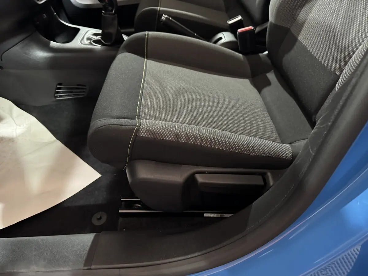 Vue rapprochée du siège avant droit gris et noir de la Citroën C3 bleu, avec levier de vitesse manuel visible.