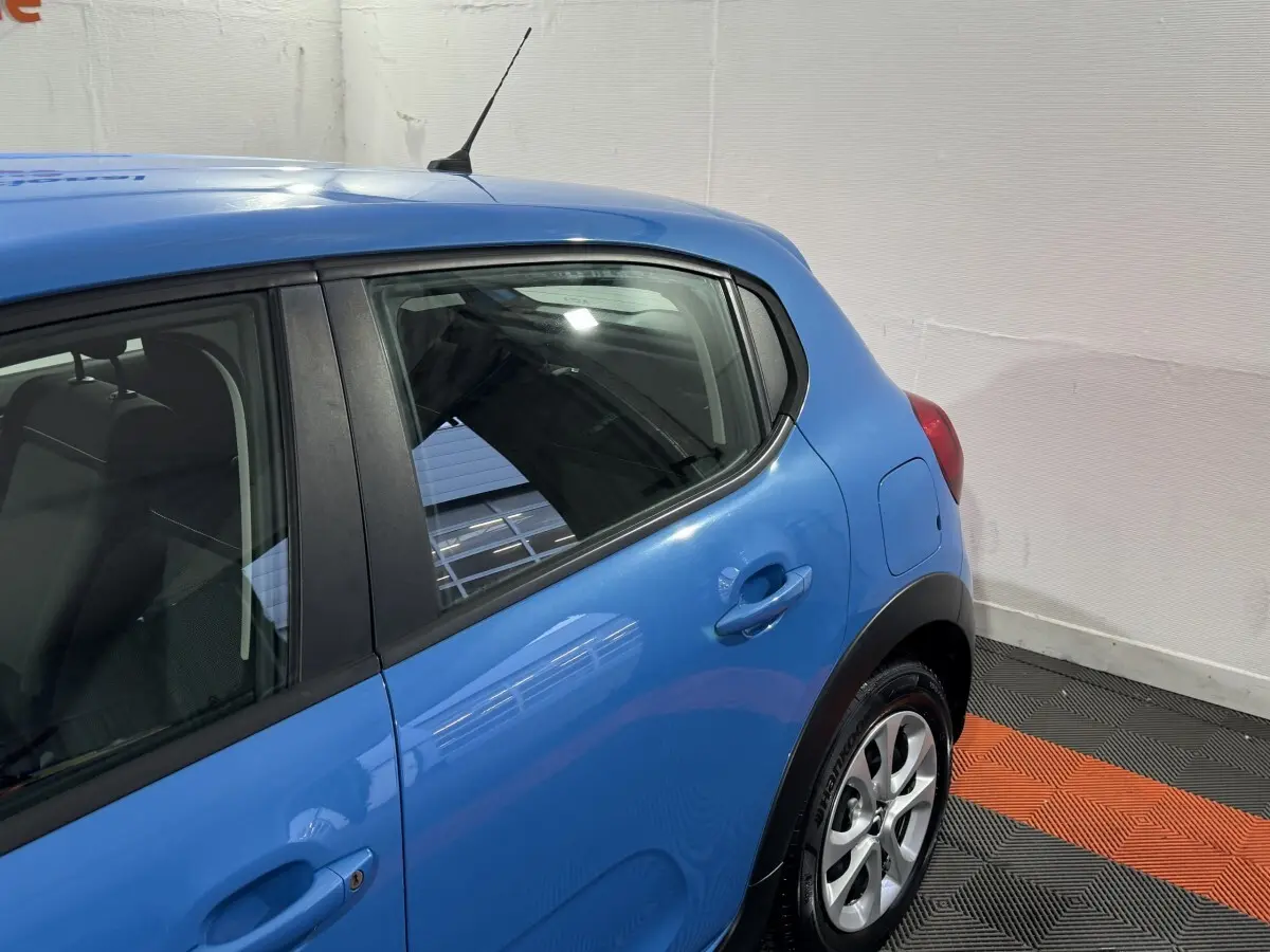 Vue côté droit arrière d'une Citroën C3 bleu vif avec poignées de porte et jante alliage visibles.