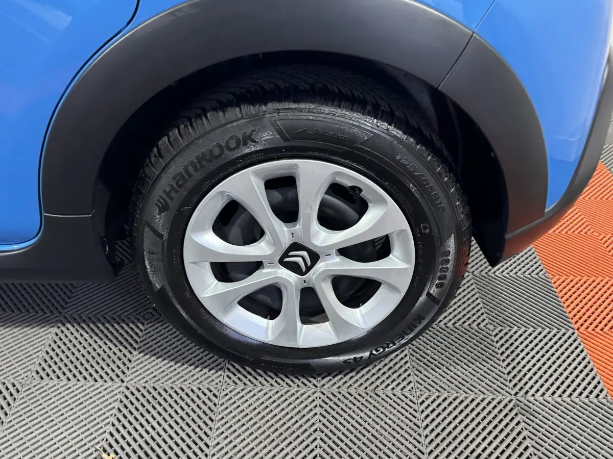 Gros plan sur la roue avant droite d'une Citroën C3 bleu 2018 avec jante argentée et logo Citroën au centre.
