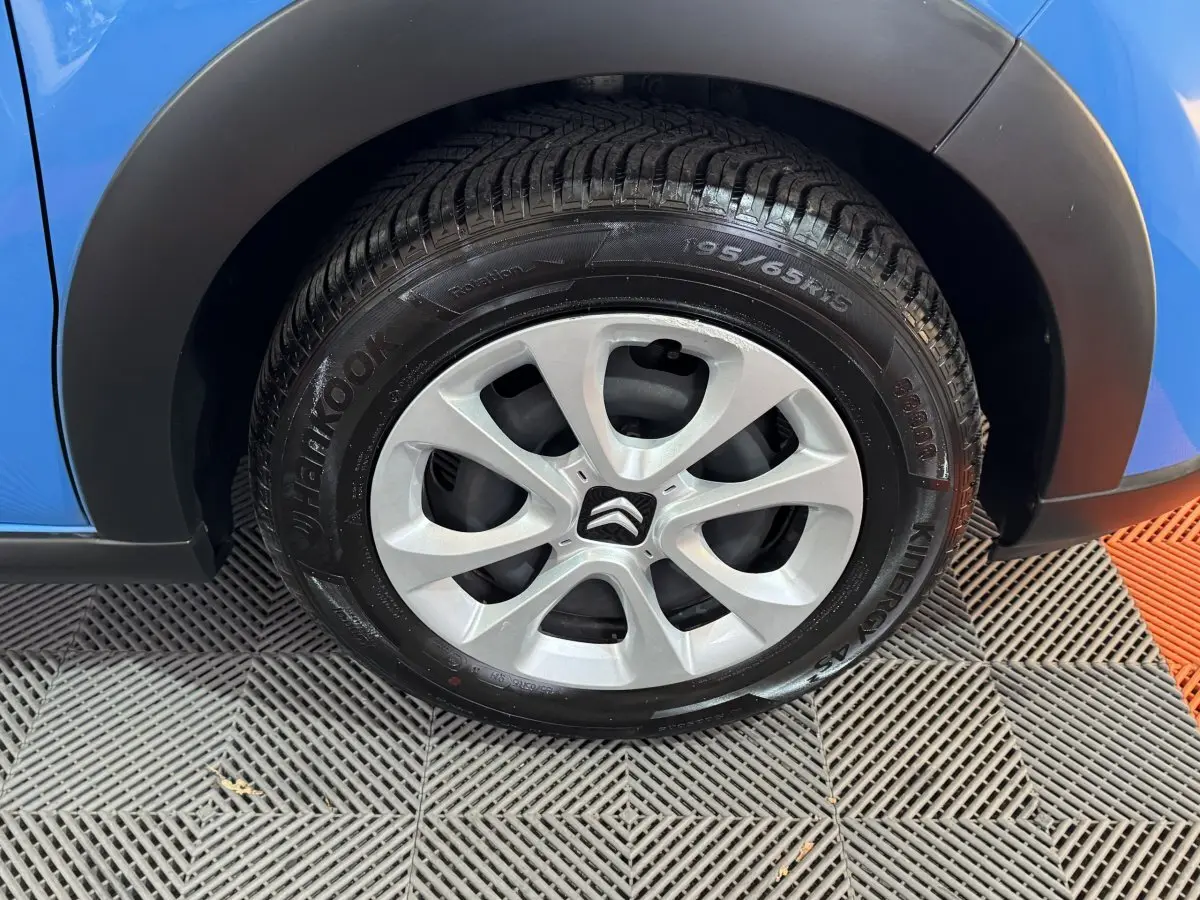 Gros plan sur la roue avant droite d'une Citroën C3 bleu 2018 avec jante alliage et pneu Hankook.