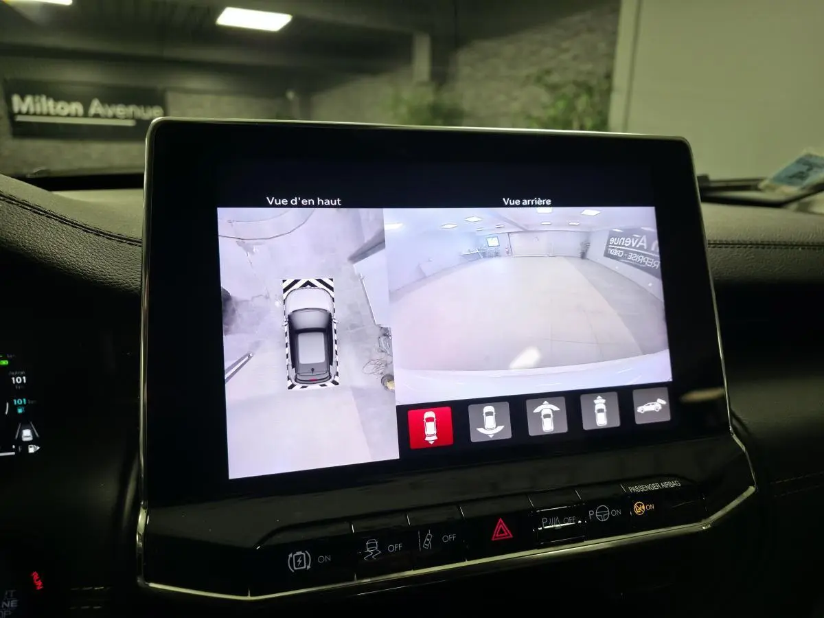 Écran central affichant la caméra 360° et vue arrière du Jeep Compass blanc en stationnement intérieur.