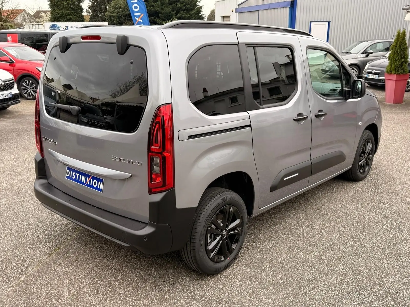 Vue 3/4 arrière droite du Citroën Berlingo gris Artense avec vitres teintées et jantes noires.