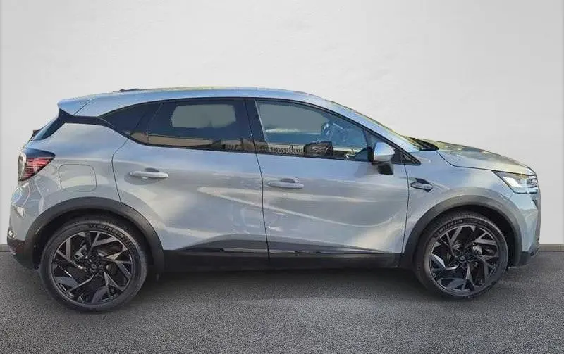 Profil droit du Renault Captur E-Tech hybride gris Rafale avec toit gris et jantes noires distinctives.